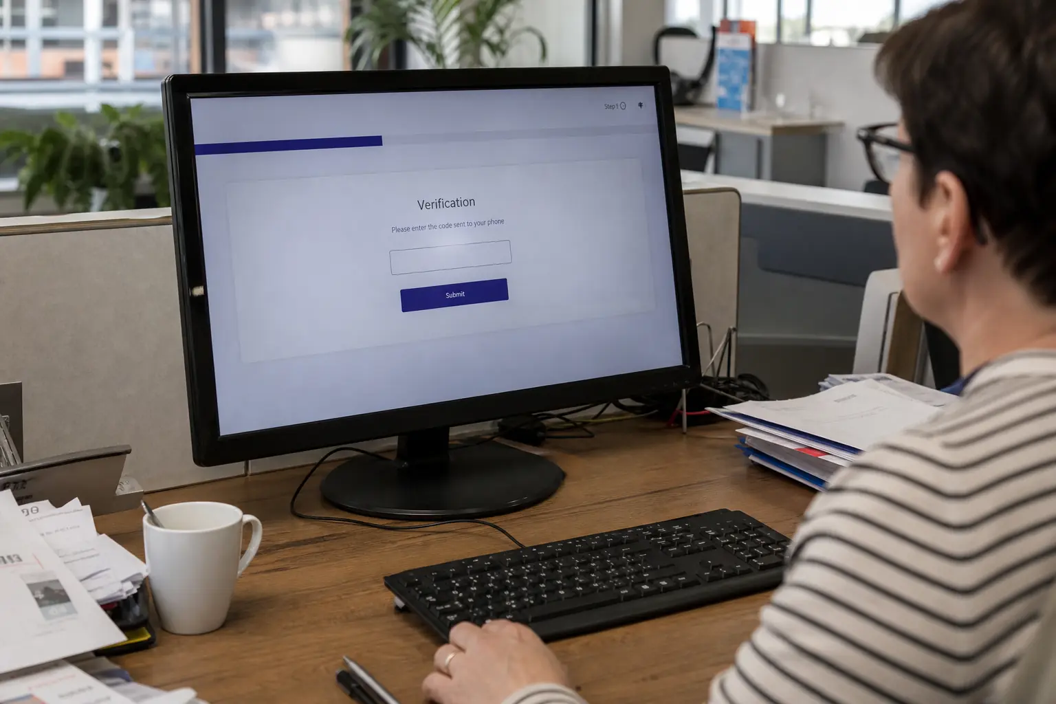 Un écran d'ordinateur affiche un formulaire de vérification, dans un bureau