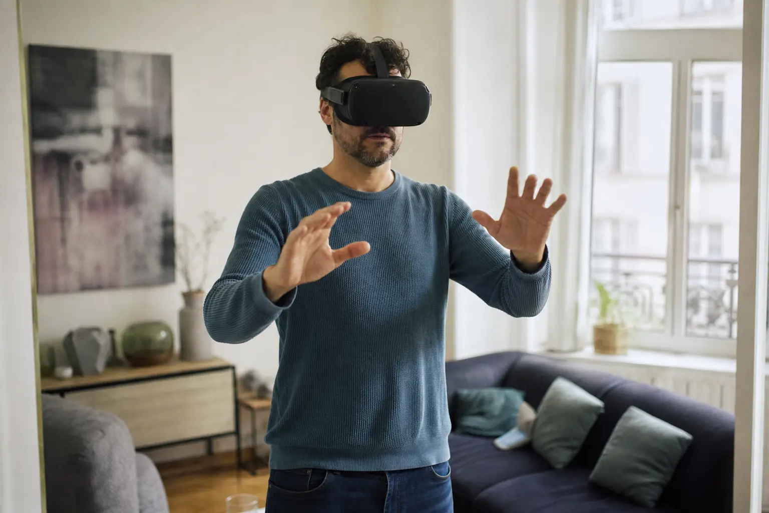 Une personne adulte porte un casque de réalité virtuelle dans un salon