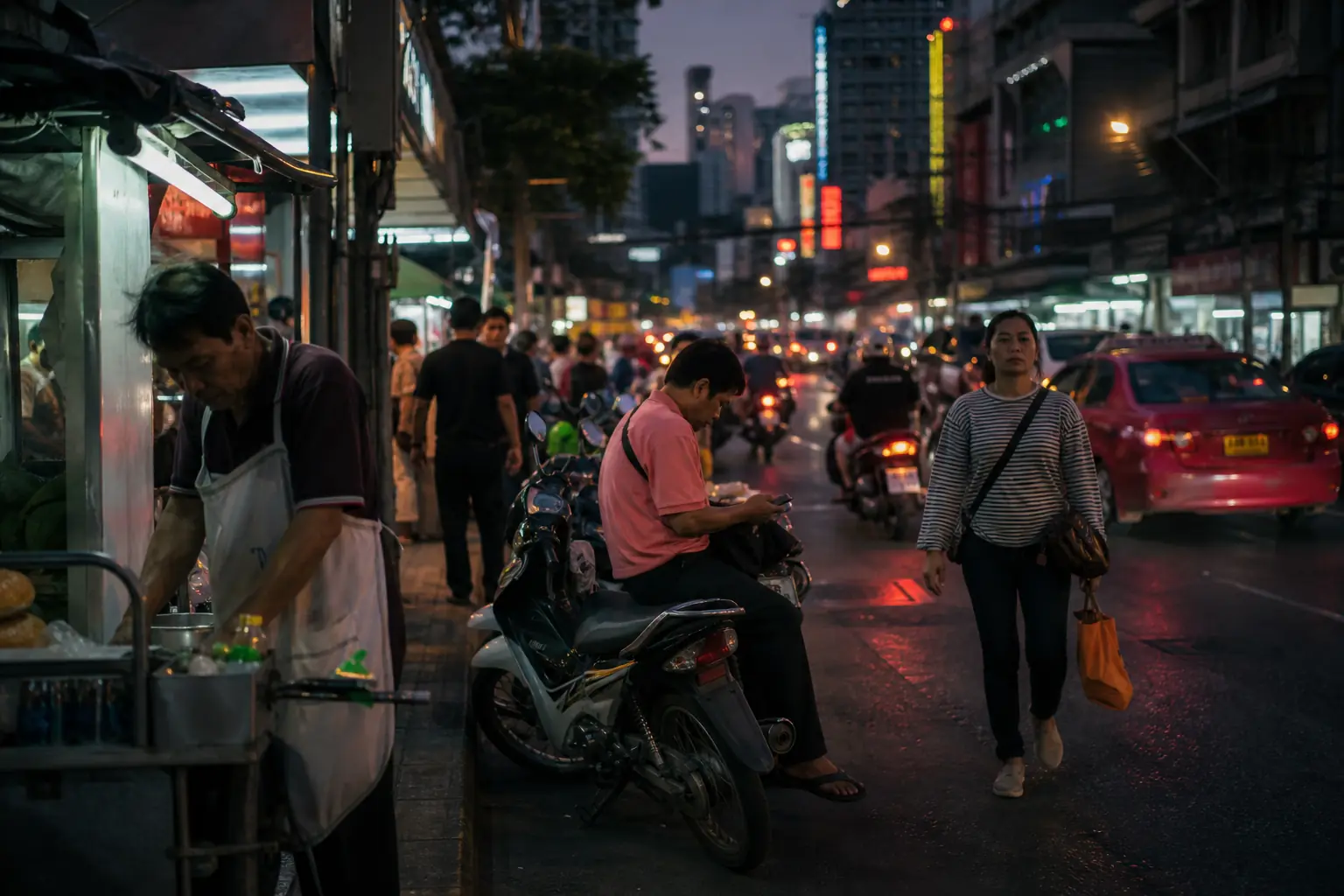 Une rue commerçante de Bangkok en soirée, enseignes lumineuses et circulation